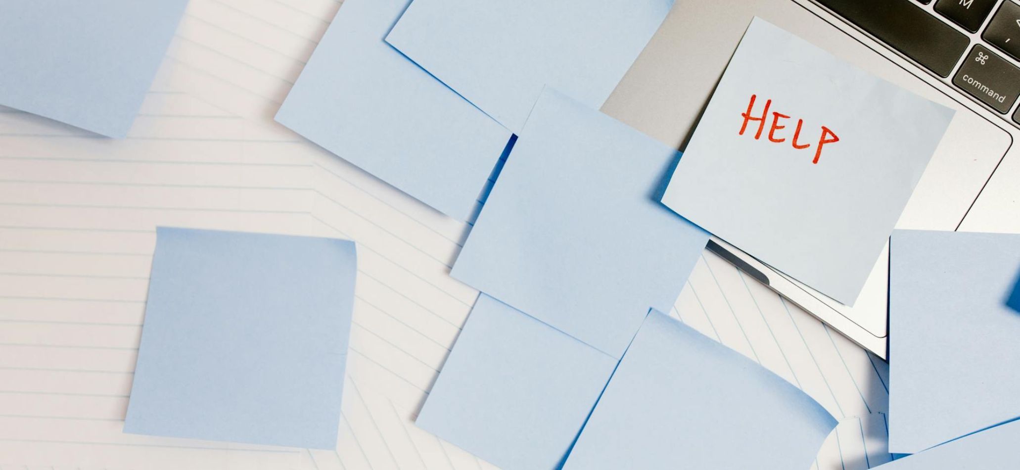 plusieurs post it bleus sont posés sur un bureau sur l'un deux il est écrit le mot 