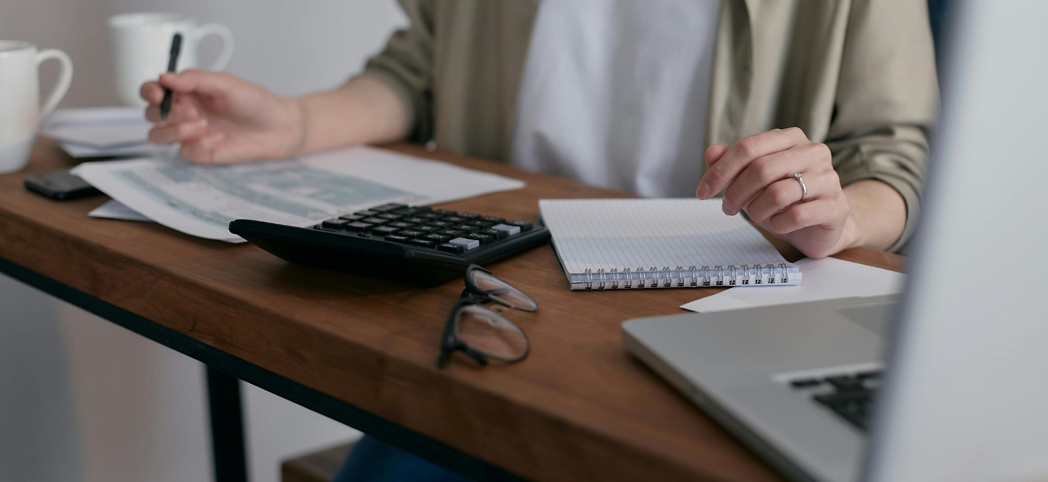 Personne en train de travailler à son bureau, remplissant une feuille de calculs