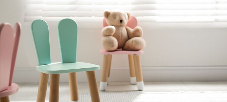 chaises pour enfants bleues et roses sur l'une desquelles est posé une peluche en forme de nounours