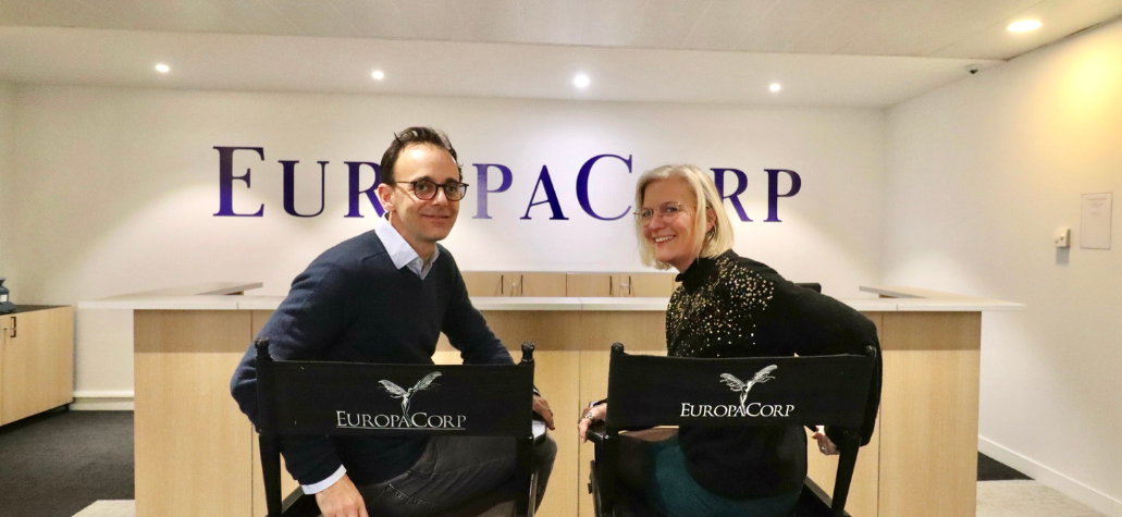 Le secrétaire général d'Europacorp et notre consultante Elyse sont assis sur des chaises de cinéma EuropaCorp et regarde l'objectif.