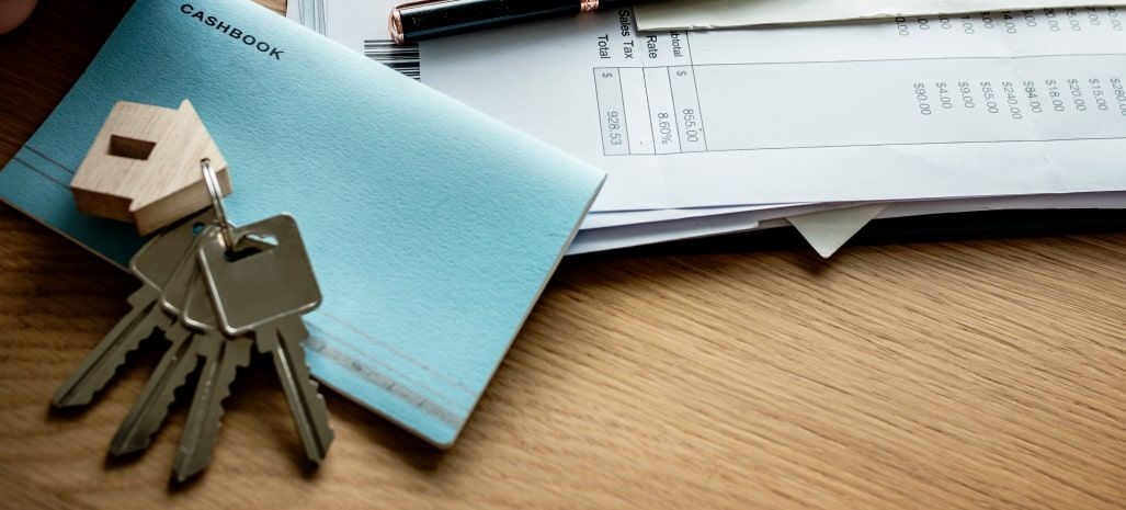 Un bureau avec des papiers un portefeuille et des clés.
