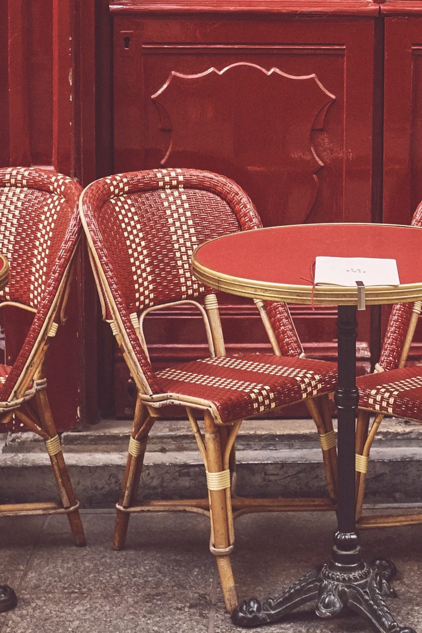 Gros plan d'une terrasse de café. Chaise et table de café rouge devant façade en bois rouge