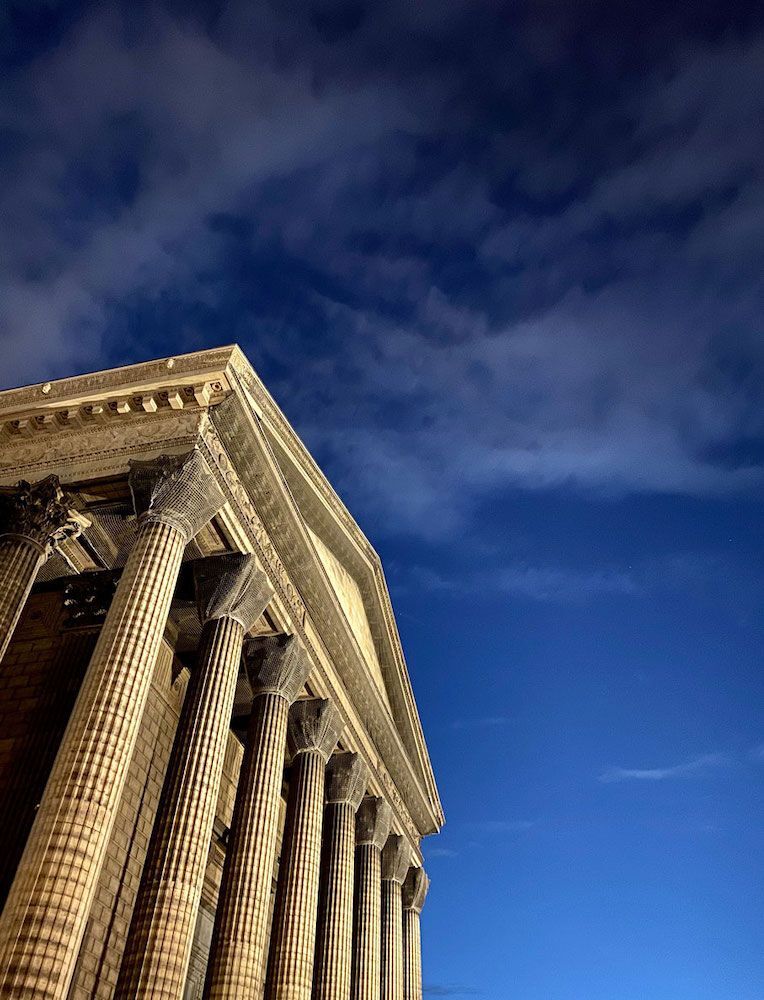 Dans le coin en bas à gauche, une partie de l'église de la madeleine avec en fond le ciel bleu