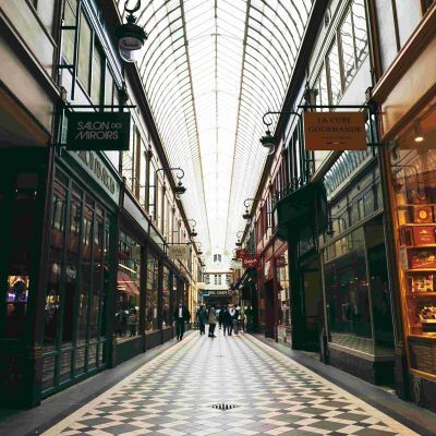 Passage Jouffroy avec de chaque côtés des magasins aux façades ancienne et panneaux anciens suspendus