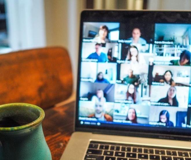 Ordinateur avec visioconférence posé sur un bureau avec une tasse de c&fé